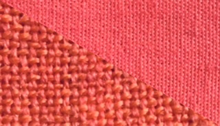 Fabric swatch dyed in salmon red, demonstrating the vibrant color achieved with our dye on different fabrics